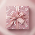 Elegant gift wrapped in pink floral wrapping paper with matching satin ribbon and "With Love" tag.
