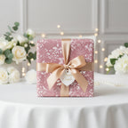 Elegant gift wrapped in mauve floral wrapping paper with gold ribbon, perfect for wedding.