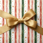 Elegant Christmas gift wrap with gold ribbon, featuring watercolor red and green stripes, Wrapped Studios.