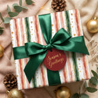Festive "Season's Greetings" gift with striped watercolor wrapping paper and green satin ribbon.