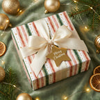 Elegant Christmas gift wrapped in watercolor stripe paper with a cream ribbon and gold star tag.