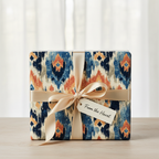 Abstract ikat gift wrapping paper in blue, orange, and cream with a gold satin ribbon and "From the Heart" gift tag.