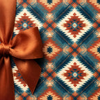 Rustic Southwestern wrapping paper with a teal and orange geometric pattern and satin bow by Wrapped Studios.