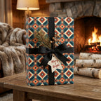 Southwestern Christmas wrapping paper by Wrapped Studios on a gift box with black ribbon by a cozy fireplace.