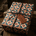 Rustic southwestern wrapping paper in teal and rust with a leather tag by Wrapped Studios.