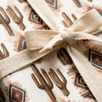 Rustic cactus wrapping paper with a southwest desert print and cotton ribbon bow by Wrapped Studios.