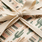 Rustic cactus wrapping paper with southwestern patterns and cream cotton ribbon by Wrapped Studios.