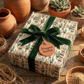 Southwestern cactus wrapping paper with a luxury green velvet bow and Wrapped Studios tag.