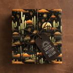 Gift wrapped in Southwestern-themed wrapping paper with cacti, desert landscape, string bow and gift tag.