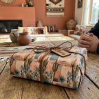 Southwestern desert cactus wrapping paper on a rustic gift tied with leather cord, by Wrapped Studios.