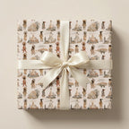 Southwestern wrapping paper with watercolor desert designs and a cream bow by Wrapped Studios.