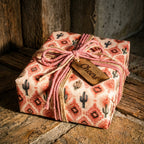 Southwest cactus wrapping paper on a rustic gift box with pink twine and Cheers wooden tag by Wrapped Studios.