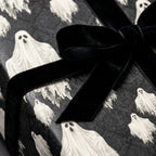Gothic ghost wrapping paper with a black velvet bow. Spooky Halloween gift wrap by Wrapped Studios.