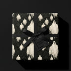 Spooky ghost Halloween wrapping paper with a black ribbon on a gift box by Wrapped Studios.