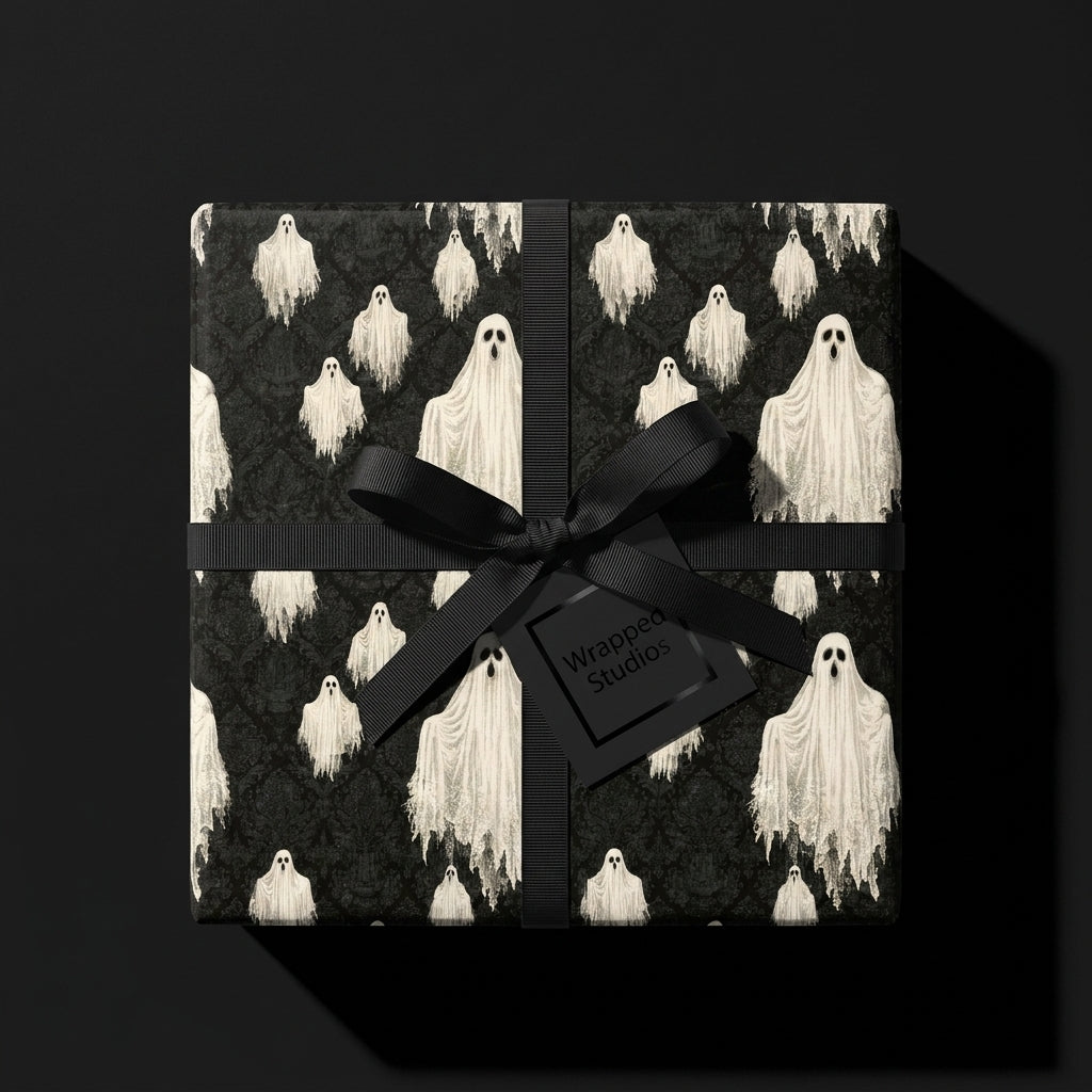 Spooky ghost Halloween wrapping paper with a black ribbon on a gift box by Wrapped Studios.