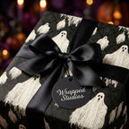 Spooky ghost Halloween wrapping paper with a black satin bow and Wrapped Studios tag.