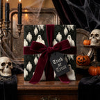 Gothic ghost Halloween wrapping paper with a luxury burgundy velvet bow by Wrapped Studios.