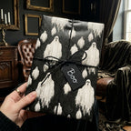 Spooky ghost Halloween wrapping paper by Wrapped Studios, on a gift tied with black twine and a "Boo" tag.