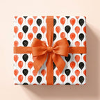 Orange and black balloon birthday wrapping paper with a matching bow by Wrapped Studios.