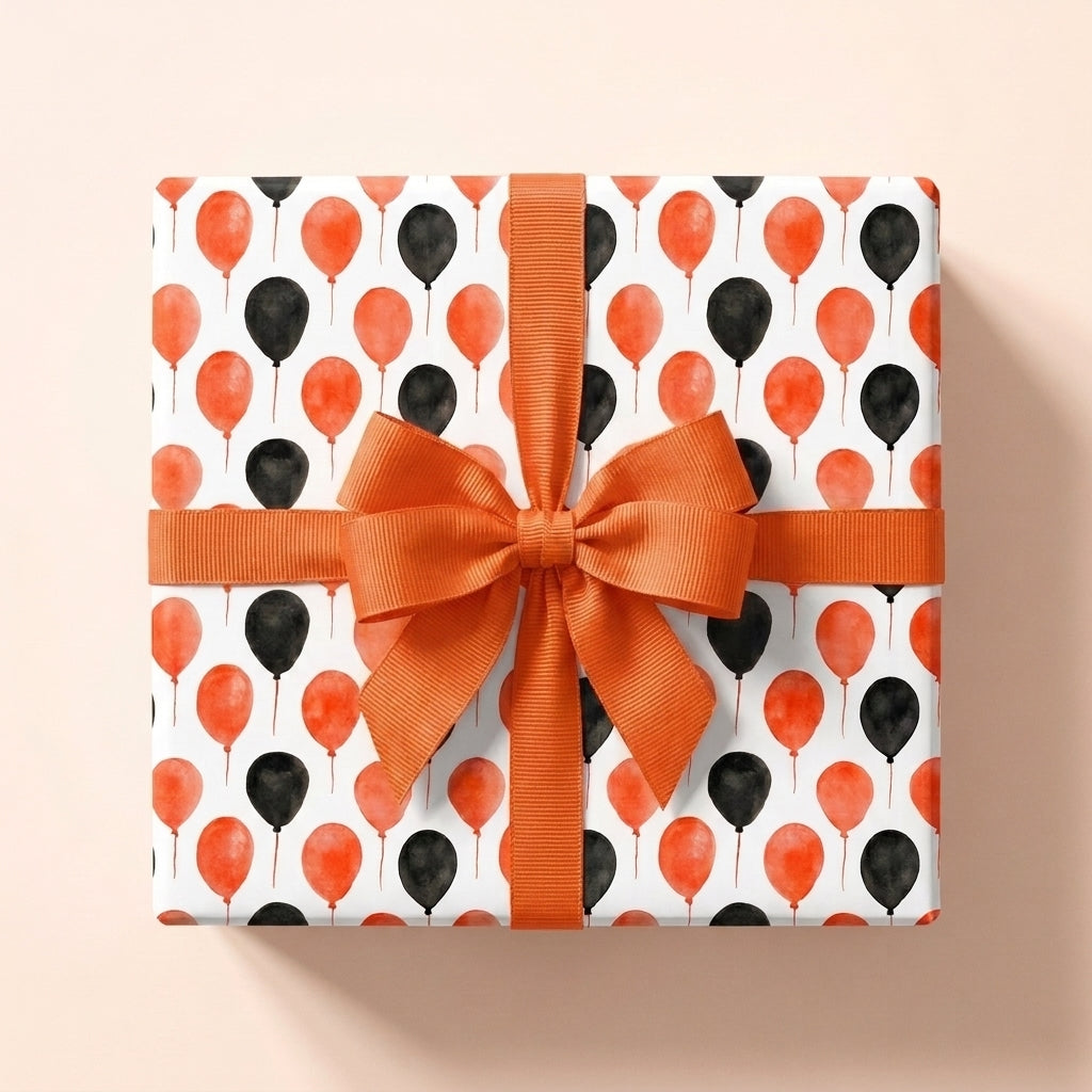 Orange and black balloon birthday wrapping paper with a matching bow by Wrapped Studios.