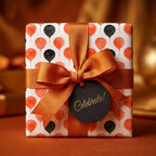Orange and black balloon birthday wrapping paper with ribbon and Celebrate tag by Wrapped Studios.