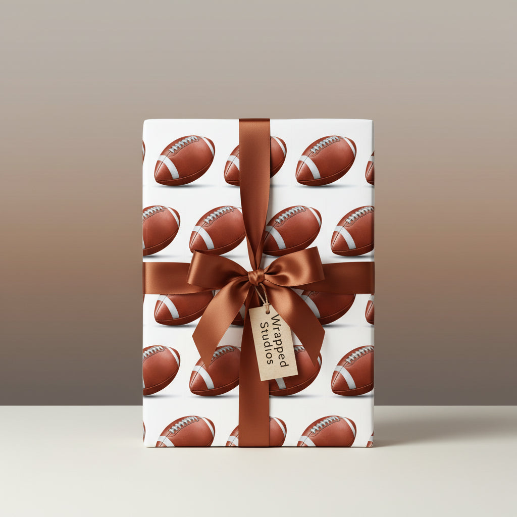 Wrapped gift features football print wrapping paper and a brown satin ribbon and bow.