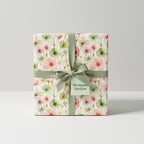 Elegant gift box in floral wrapping paper with a sage green ribbon.