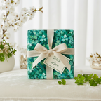 Elegant gift wrapped in green shamrock wrapping paper with cream ribbon and "With Love" tag.