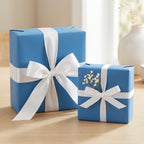 Two gifts wrapped in solid blue wrapping paper with white ribbon and bows.