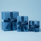 Three blue gift boxes wrapped in solid color wrapping paper with dark blue velvet ribbon bows.