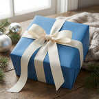 Solid blue gift box wrapped with a wide cream ribbon, perfect for Christmas presents or elegant birthday gift wrapping.