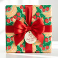 Cute fruit wrapping paper with strawberries and bananas by Wrapped Studios, finished with a red satin bow.