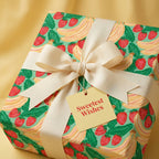 Cute strawberry and banana birthday wrapping paper with a cream bow and gift tag by Wrapped Studios.