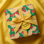Cute strawberry and banana birthday gift wrap with a yellow bow, by Wrapped Studios.