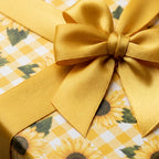 Sunflower floral wrapping paper with yellow gingham and a gold satin bow by Wrapped Studios.