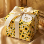 Sunflower wrapping paper with yellow gingham pattern, cream ribbon, and gift tag by Wrapped Studios.