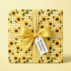 Sunflower wrapping paper with yellow gingham, a satin bow, and a Wrapped Studios gift tag.