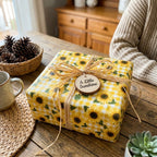 Sunflower wrapping paper in yellow gingham with a rustic raffia bow by Wrapped Studios.