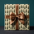 Bullet wrapping paper with bronze satin bow on gift box, unique military gift wrap by Wrapped Studios.