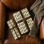 Masculine bullet wrapping paper on rustic gifts on a leather chair by Wrapped Studios.