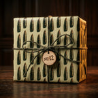 Rustic bullet wrapping paper with ammunition pattern on an olive green gift box by Wrapped Studios.