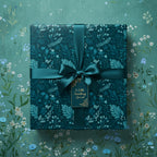 Teal square gift box wrapped in floral wrapping paper with satin ribbon and gift tag.