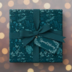 Elegant square gift box wrapped in teal floral wrapping paper with ribbon, bow, and "Special Delivery" tag.