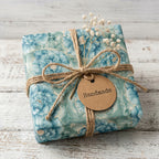 Elegant blue floral wrapping paper with twine bow and handmade tag by Wrapped Studios.
