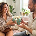Cute teal banana wrapping paper on a gift box held by a smiling couple. Wrapped Studios.