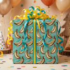 Playful banana wrapping paper in teal with a yellow bow on a birthday gift box by Wrapped Studios.