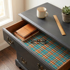 Teal and orange plaid wrapping paper styled as a drawer liner in a dark wood desk, by Wrapped Studios.