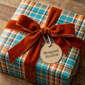 Rustic teal and orange plaid wrapping paper with a burnt orange velvet bow by Wrapped Studios.