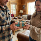 Rustic teal plaid wrapping paper with a burlap bow on a gift exchanged in a cozy cabin by Wrapped Studios.