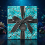 Wrapped gift with turquoise marbled gift wrap and gray velvet ribbon on a reflective surface.